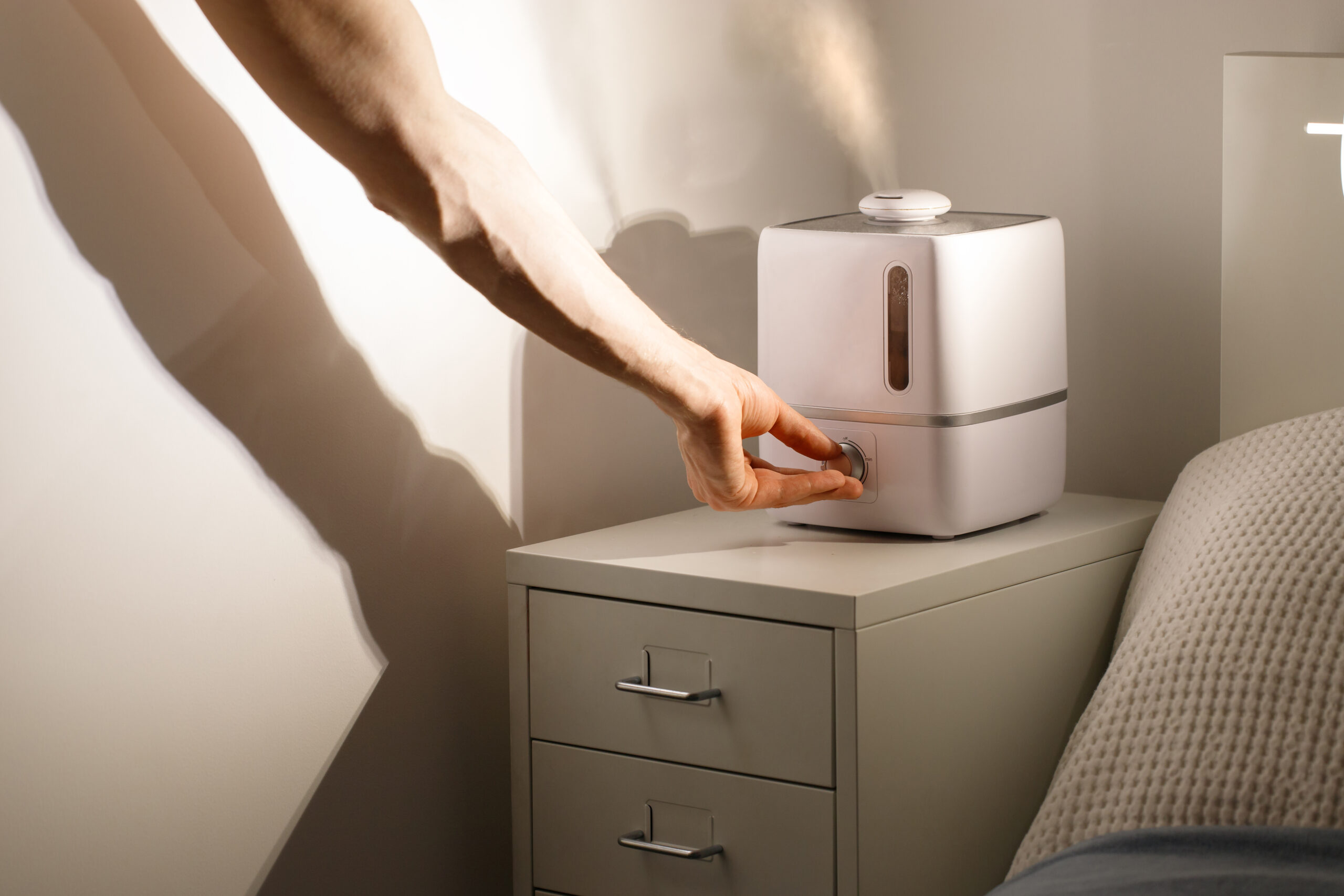 Hand turn on humidifier on the bedside table